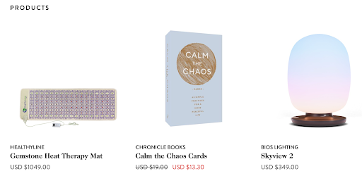 Wellness product lineup featuring a gemstone heat therapy mat, "Calm the Chaos" mindfulness cards, and a Skyview 2 circadian rhythm lamp.