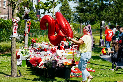 "Liverpool football fans laying flowers and balloons marked ‘20’ at a memorial site in tribute to late player Diogo Jota